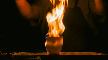 Burning ceramic mug on pottery wheel in workshop, studio. Handmade, art and handicraft conceptの写真素材