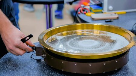 Sound vibration transforms white sand particles on steel surface at technology futuristic exhibition. Science, resonance and physics conceptの写真素材