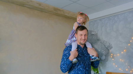Portrait of funny little girl and her father at home. Family, childhood and leisure conceptの写真素材