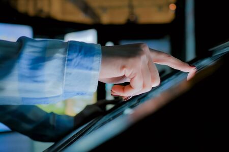 Education and technology concept - woman using interactive touchscreen display of electronic kiosk at modern history museumの写真素材