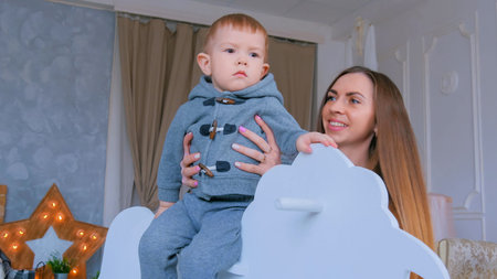 Little boy playing on white wooden rocking horse. Family, childhood, game and leisure conceptの写真素材