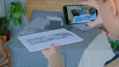 MOSCOW, RUSSIA - AUGUST 10, 2018. Woman using smartphone with augmented reality app - planets of solar system. Future, astronomy and technology conceptのeditorial素材