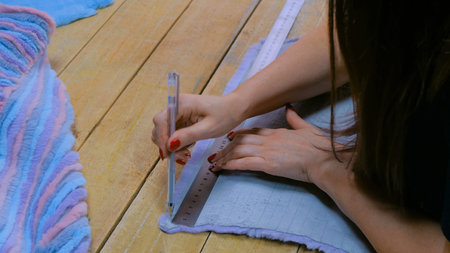 Professional woman skinner, furrier working with mink fur skin at atelier, workshop. Fashion and...