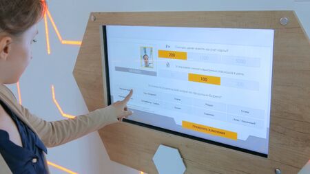 MOSCOW, RUSSIA - July 30, 2018: Smart City Exhibition. Woman using interactive touchscreen display at modern technology showのeditorial素材