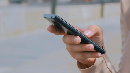 Woman using smartphone on embankment - scrolling and touching
