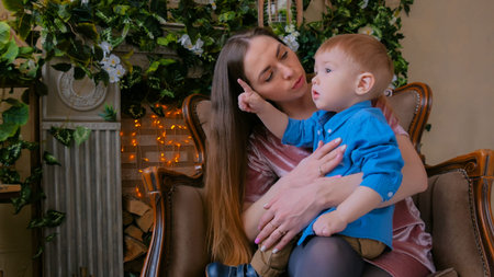 Young mother and her baby son sitting togerher at home. Family, childhood and leisure concept