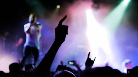 Silhouettes of people partying at rock concert in front of the stage. Entertainment and leisure conceptの写真素材