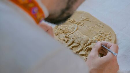 Professional male potter making clay stamp picture. Handwork, crafting and traditional arts conceptの写真素材