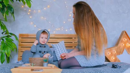 Young mother and her baby son playing togerher at home. Family, childhood and leisure conceptの写真素材