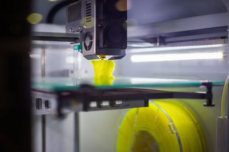 3D printer prints physical 3D model with plastic wire filament at modern technology exhibition. Additive technologies, science and futuristic conceptの写真素材