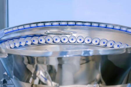 Pharmaceutical automatic production line - conveyor system for plastic bottle caps at pharmacy processing factory. Manufacturing, pharma industry, medicine and automated technology equipment conceptの写真素材