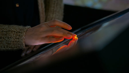 Woman using interactive touchscreen display in modern historical museum. Evening time, lowlight....