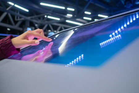 Woman hand using interactive touchscreen display of electronic multimedia terminal at modern...