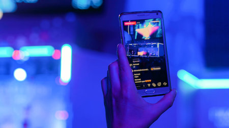 Unrecognizable man hands silhouette recording video of live music concert with smartphone....