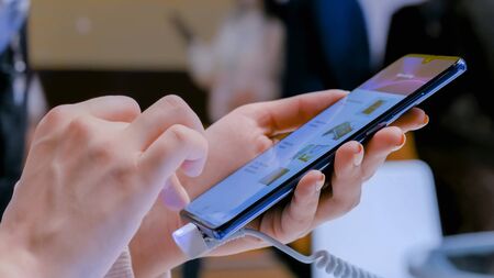 MOSCOW, RUSSIA - March 1, 2019: Woman testing new model of Huawei smartphone in electronic shop, store. Prototype, consumerism, entertainment and new technology conceptのeditorial素材