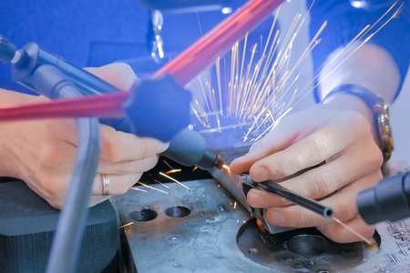 Professional male welder trying gas tungsten arc welding GTAW or tungsten inert gas TIG technology...
