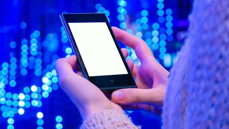 Mock up, furute, sci-fi, template and technology concept - woman looking at vertical smartphone with white blank screen at modern scifi technology exhibitionの写真素材