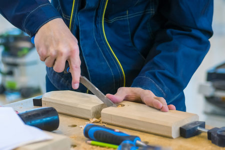 Professional man carpenter using chisel to carve wood on rough workbench at workshop. Design,...