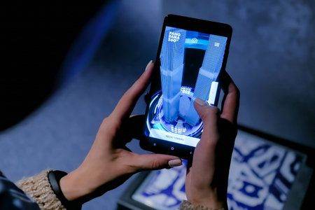 MOSCOW, RUSSIA - March 1, 2019. Woman using smartphone with augmented reality app and spinning...