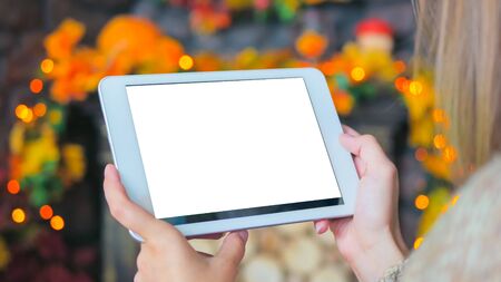 Woman looking at horizontal tablet computer with white blank screen. Mock-up, holiday, template and technology conceptの写真素材