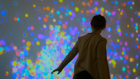 Large screen augmented reality experience - woman moving hands in front of display. Science, future...