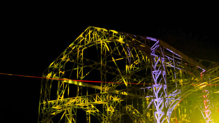 Colorful light video mapping multimedia show projected on metal construction of warehouse building...