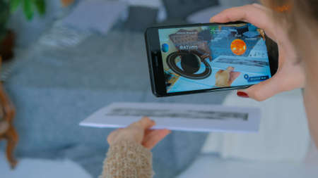 MOSCOW, RUSSIA - AUGUST 10, 2018. Woman using smartphone with augmented reality app - planets of solar system. Future, astronomy and technology conceptのeditorial素材