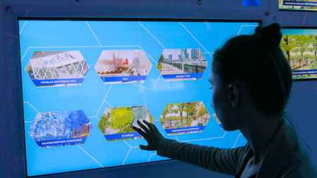 MOSCOW, RUSSIA - July 30, 2018: Smart City Exhibition. Woman using interactive touchscreen display...