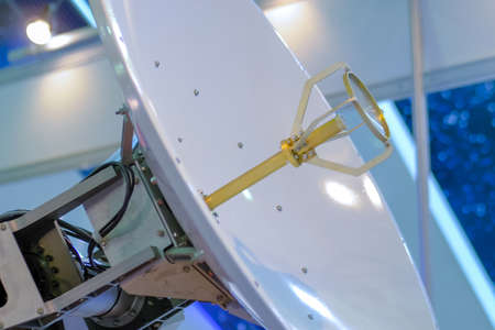 White rotating satellite dish antenna, VSAT parabolic receiver using to receive or transmit information at telecommunication exhibition: side view. Broadcasting, communication, technology conceptの写真素材
