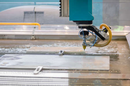 Fast extreme cnc automatic waterjet cutting machine working with sheet metal by high-pressure water jet and abrasive substance. Metalworking, industrial, manufacturing, technology conceptの写真素材