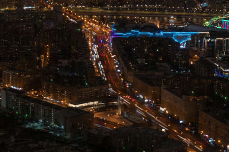 Aerial drone view on Moscow city street with fast moving cars traffic and lights trail. Warm illumination at night. Rush hour, urban, transportation and city life conceptの写真素材