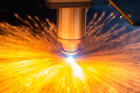 Laser cutting machine working with sheet metal with many sparks in dark at factory, plant: close up. Metalworking, industrial, equipment, technology, machining, manufacturing conceptの写真素材