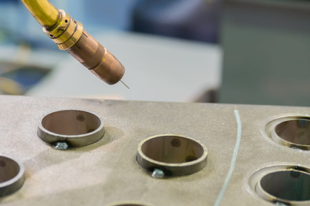 Industrial welding robot for gas metal arc welding working with metal workpiece at robotic...