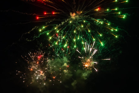 Colorful bright fireworks in dark sky at night. Evening time, low light illumination. Holiday,...