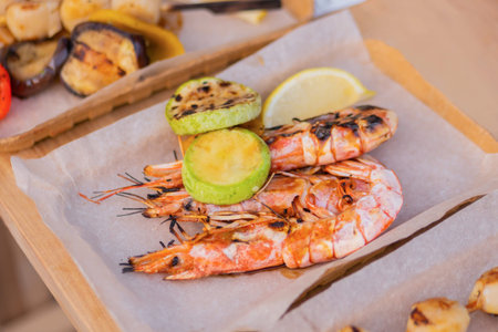 Cooked fresh red langoustine shrimps, prawns in paper take out box at summer local food market -...