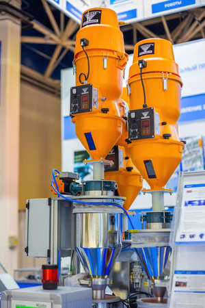 MOSCOW, RUSSIA - JUNE 05, 2019: Plastic exhibition. Orange gravimetric dosing mixing system - Koch technik at trade show. Technology, production, manufacturing, industrial, automatic equipment conceptのeditorial素材