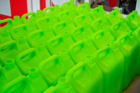 Many empty green plastic jerrycans in warehouse, market, factory or exhibition