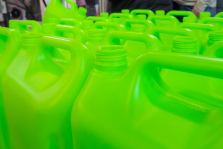 Many empty green plastic jerrycans in warehouse, market, factory or exhibition