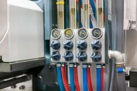 Flowmeter, rotameter - water flow regulator for cooling system of injection moulding machine at plant, factory - close up. Measuring and control equipment conceptの写真素材