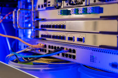 Telecommunication technology equipment - fiber optic cables and switch at server room, data center - close up. Network, transfer, traffic, web, hardware, connection and internet conceptの写真素材
