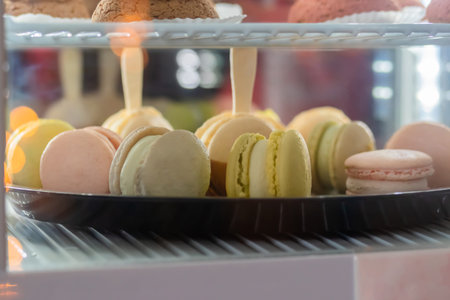 Assortment of delicious fresh macaroons with cream on counter for sale at restaurant, cafe, bakery....