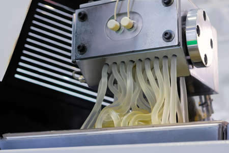 Waste plastic recycling machine: process of melting polyethylene at plant, factory - close up view. Environmental protection, industrial, automated technology conceptの写真素材