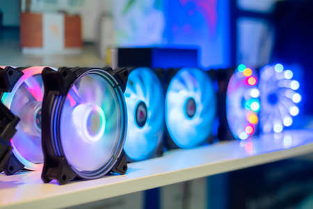 Many colorful pc coolers, cooling fans with neon LED light on table at computer exhibition, trade show - close up view. Technology, gaming, equipment, electronic conceptの写真素材
