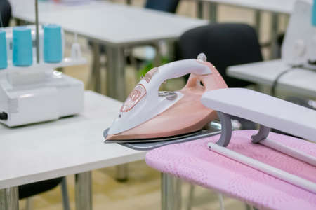 Professional tailor, fashion designer workplace - sewing machine, ironing board at atelier, studio. Fashion, clothing industry, needlework, manufacturing and tailoring conceptの写真素材