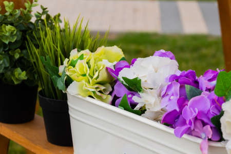 Pots with beautiful blooming flowers on wooden shelf at summer festival - close up view. Floristry, outdoor decor, artwork and decoration conceptの写真素材