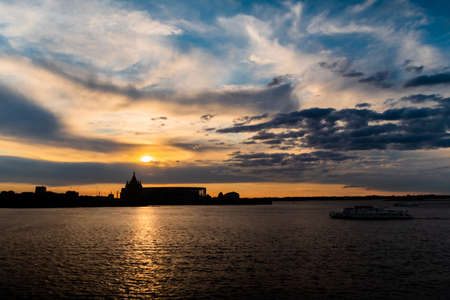 Dramatic colorful golden susnet sky with clouds over the Volga river - sun goes down, evening time, warm light. Calm, peaceful, atmospheric view, relaxation conceptの写真素材