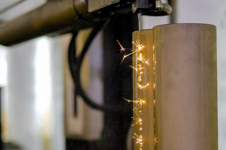 Automatic cnc wire cutting machine working with metal workpiece with sparks at factory, plant. Metalworking, industrial, machining, technology, manufacturing, equipment conceptの写真素材