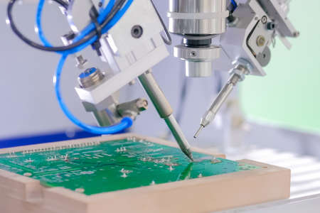 Automated technology, industrial, robotic, electronic, production, manufacturing concept. Close up: process of selective soldering components to printed circuit boards at exhibition, factoryの写真素材