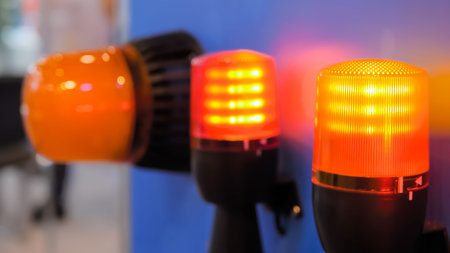 Close up of alarm lamp signal warning flashing lights on blue wall for industrial machinery at...