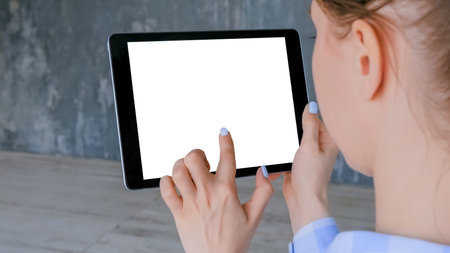 Woman hand using black digital tablet computer device with interactive white blank screen -...